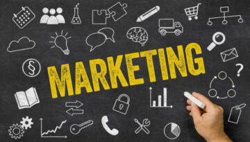 Marketing written on a blackboard with icons